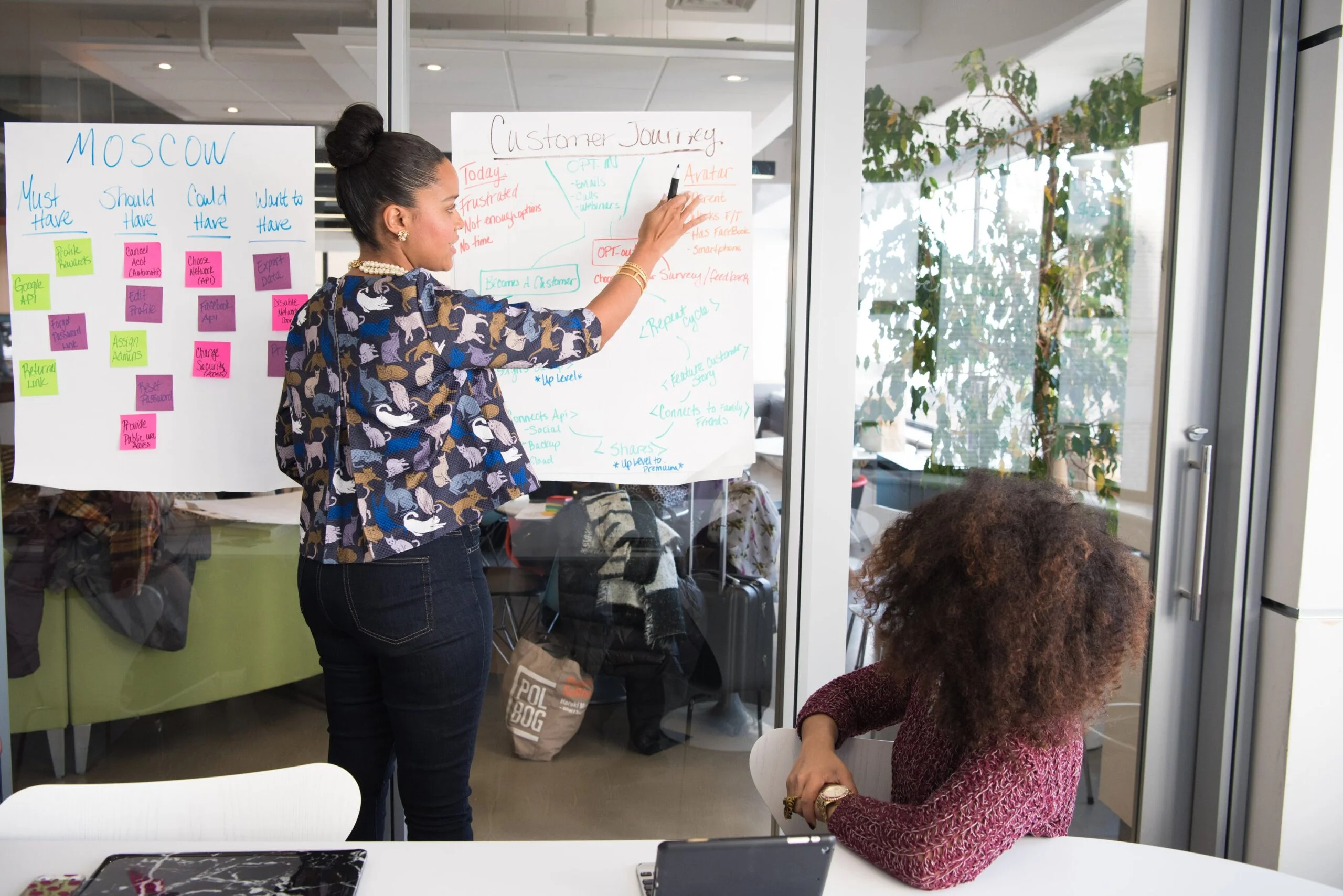 competitve_advantage Young black entrepreneur of small company putting a adhesive note on glass in office during team meeting to determine competitive advantage